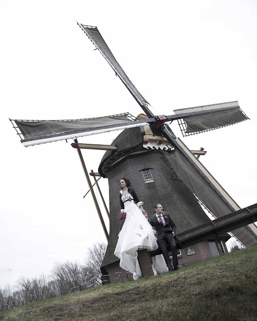Getrouwd paar poseert bij de molen van Vrieze's erfgoed