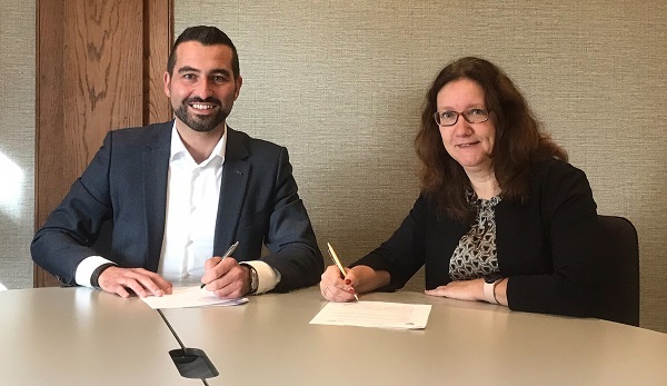 Wethouder Stephan Nienhuis en directeur van Triada Jolanda van Loon tekenen de overeenkomst.